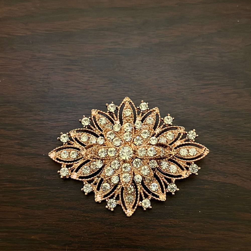 Rose gold and rhinestone brooch.